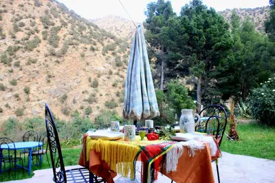 a table with a table cloth on it with mountains in the background at Ourika Atlas Tigmi in Ourika