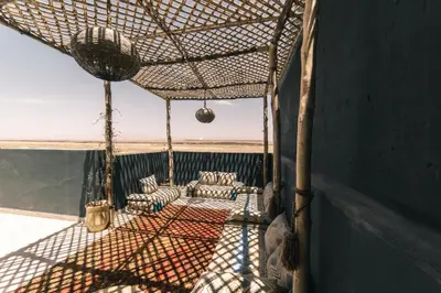 a screened porch with chairs and a net at The Kozyhome in Ouarzazate