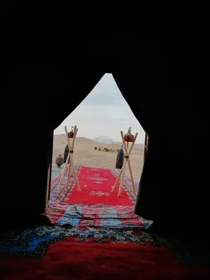 a view of the beach through a tent with a rug at Majorelle Desert Camp in Zagora