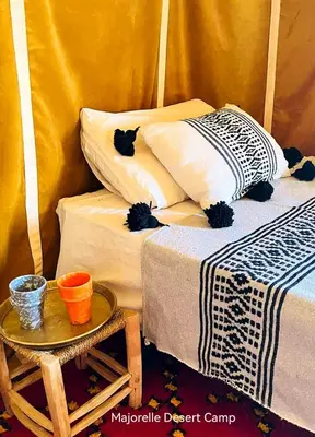 a room with two beds and a table at Majorelle Desert Camp in Zagora