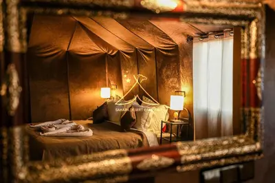 a reflection of a bedroom with a bed in a mirror at Sahara Desert Camping - Merzouga Luxury Camp in Erfoud
