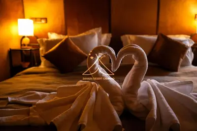 two swans are sitting on a bed with towels at Sahara Desert Camping - Merzouga Luxury Camp in Erfoud