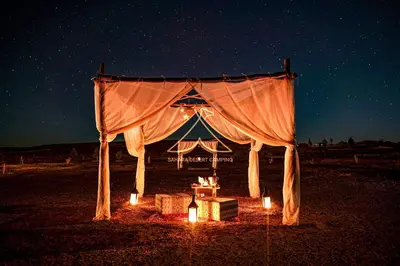 a tent with lights in the middle of the night at Sahara Desert Camping - Merzouga Luxury Camp in Erfoud