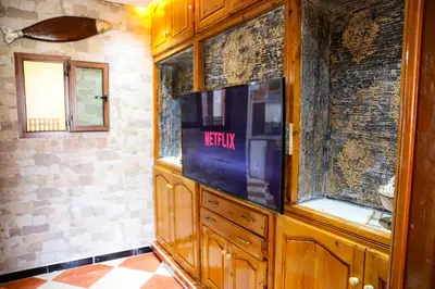 a tv in a wooden cabinet in a room at Salam appartement climatisé hiver et été in Azrou