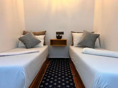 two beds sitting next to each other in a room at Salam appartement climatisé hiver et été in Azrou