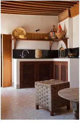 a kitchen with a table and a counter with some baskets at Riad Dar Rafti - Restaurant & Rooms with en-suite in Fès