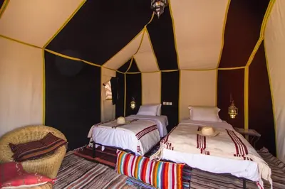 a room with two beds in a tent at sand rose luxury camp in Merzouga