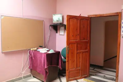 a room with a table and a screen and a door at Chez l'habitant (Ba Omar) in Zagora