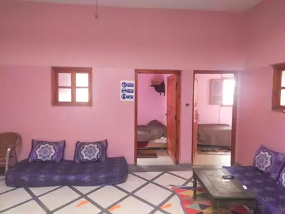 a room with a couch and a table and a mirror at Chez l'habitant (Ba Omar) in Zagora
