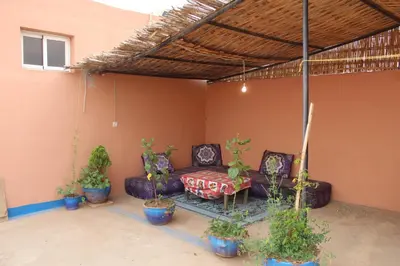 a patio with a couch and some potted plants at Chez l'habitant (Ba Omar) in Zagora