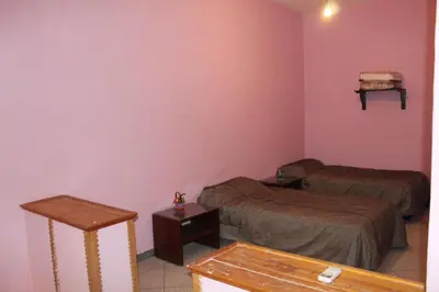 a small room with two beds and a table at Chez l'habitant (Ba Omar) in Zagora