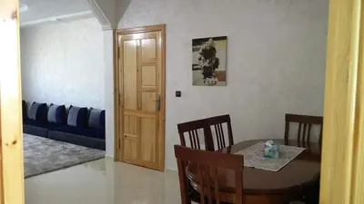 a living room with a table and a couch at LOGEMENT HOTEL et NAVETTE GRATUITE in Fès