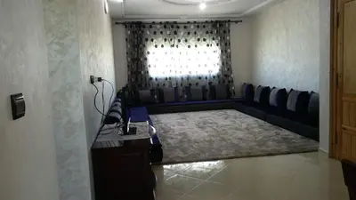 a living room with a couch and a window at LOGEMENT HOTEL et NAVETTE GRATUITE in Fès