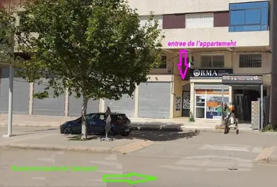 a street with a car parked in front of a store at LOGEMENT HOTEL et NAVETTE GRATUITE in Fès