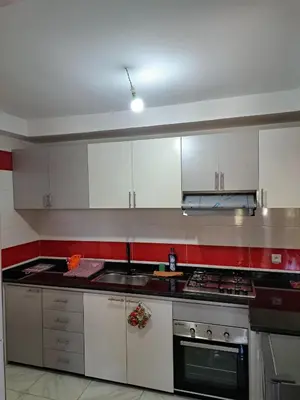 a kitchen with white cabinets and a stove top oven at Appartement Au Centre Ville Prés de la Medina in Fès