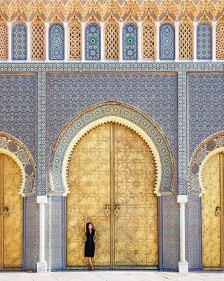 a woman standing in front of a large door at Appartement Au Centre Ville Prés de la Medina in Fès