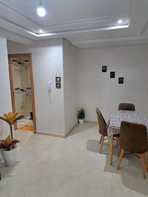 a dining room with a table and chairs in a room at Appartement Au Centre Ville Prés de la Medina in Fès
