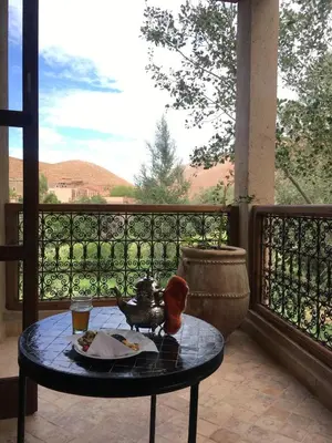 a table with a plate of food on a balcony at Chez Ichou in Aït Idaïr