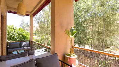 a screened in porch with a table and chairs at Chez Ichou in Aït Idaïr