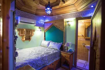 a bedroom with a king sized bed with blue lighting at Riad Mehdi Meknès in Meknès