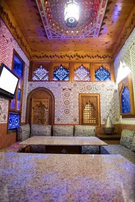 a room with a table and chairs and a ceiling at Riad Mehdi Meknès in Meknès