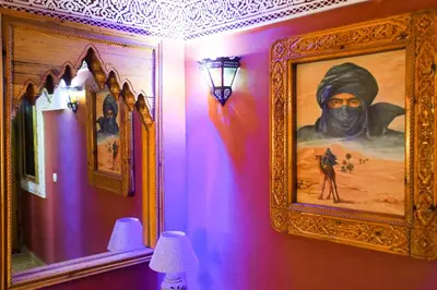 a room with a painting on a wall with purple walls at Riad Mehdi Meknès in Meknès