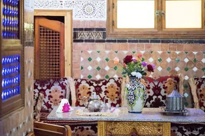 a table with a vase of flowers on a table at Riad Mehdi Meknès in Meknès
