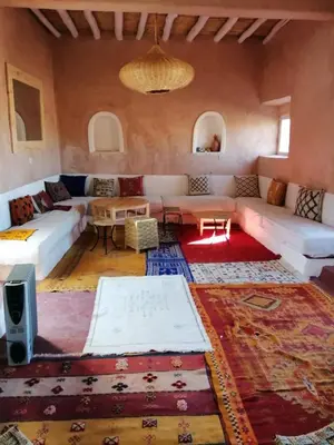 a living room with a couch and a table at Tigmi Hamid Découverte des traditions et de la culture berbère in Aït Ben Haddou