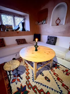 a living room with a table and a couch at Tigmi Hamid Découverte des traditions et de la culture berbère in Aït Ben Haddou