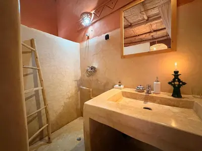 a bathroom with a sink and a ladder and a mirror at Tigmi Hamid Découverte des traditions et de la culture berbère in Aït Ben Haddou