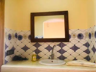 a bathroom with a sink and a mirror at Riad Hotel Les Flamants in Merzouga