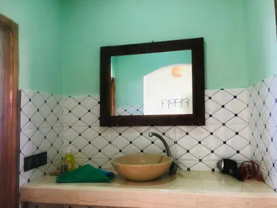 a bathroom with a sink and a mirror on a counter at Riad Hotel Les Flamants in Merzouga