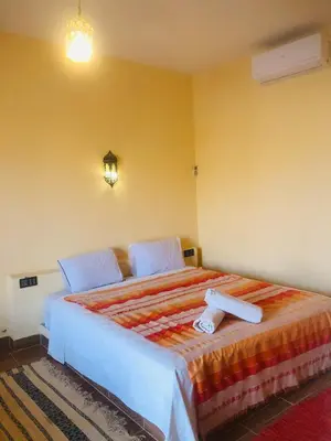 a bedroom with a large bed in a room at Riad Hotel Les Flamants in Merzouga