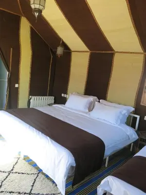 a bedroom with two beds in a tent at Mirage Luxury Camp in Merzouga