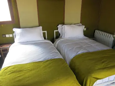two beds sitting next to each other in a room at Mirage Luxury Camp in Merzouga