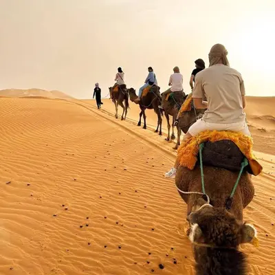 a group of people riding horses in the desert at Mirage Luxury Camp in Merzouga