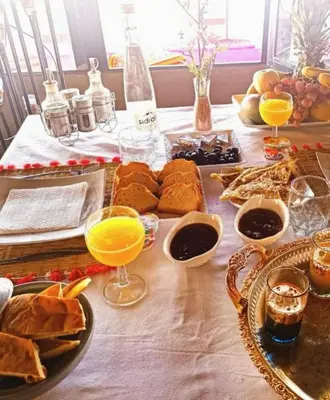 a table with food and glasses of orange juice at Mirage Luxury Camp in Merzouga