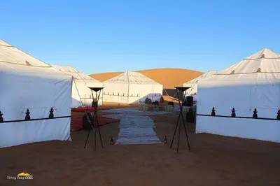 a group of tents in the middle of the desert at bassou luxury camp in Merzouga