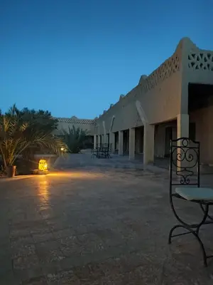 a bench in front of a building at night at Sahara Sands Hotel in Merzouga
