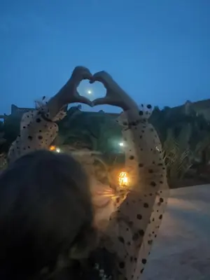 a person making a heart sign with their hands at Sahara Sands Hotel in Merzouga