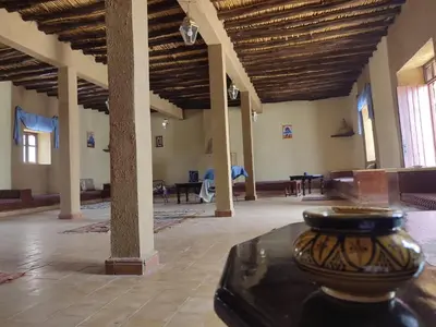 a large room with tables and chairs in a building at Sahara Sands Hotel in Merzouga