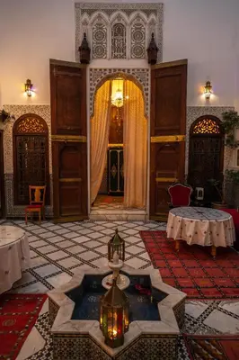 a room with a fountain in the middle of a building at Riad Arabella in Fès