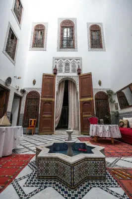 a building with a fountain in the middle of a room at Riad Arabella in Fès