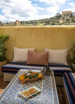 a table with a tray of food on a balcony at Riad Arabella in Fès