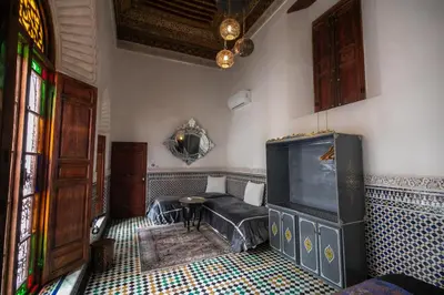 a living room with a large tv and a couch at Riad Arabella in Fès