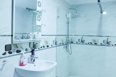 a white bathroom with a shower and a sink at HOTEL BORJ EL ARAB in Khouribga