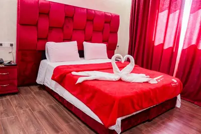 a red bed with two white towels on it at HOTEL BORJ EL ARAB in Khouribga