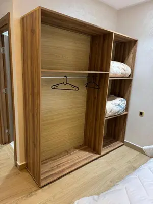 a closet with a wooden door in a bedroom at HOTEL BORJ EL ARAB in Khouribga