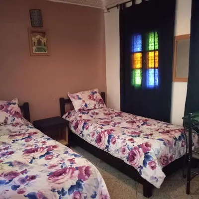 a bedroom with two beds and a stained glass window at 105 Kasbah de Boujloud Fes Morocco. in Fès