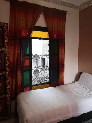 a bedroom with a bed and a window with curtains at 105 Kasbah de Boujloud Fes Morocco. in Fès